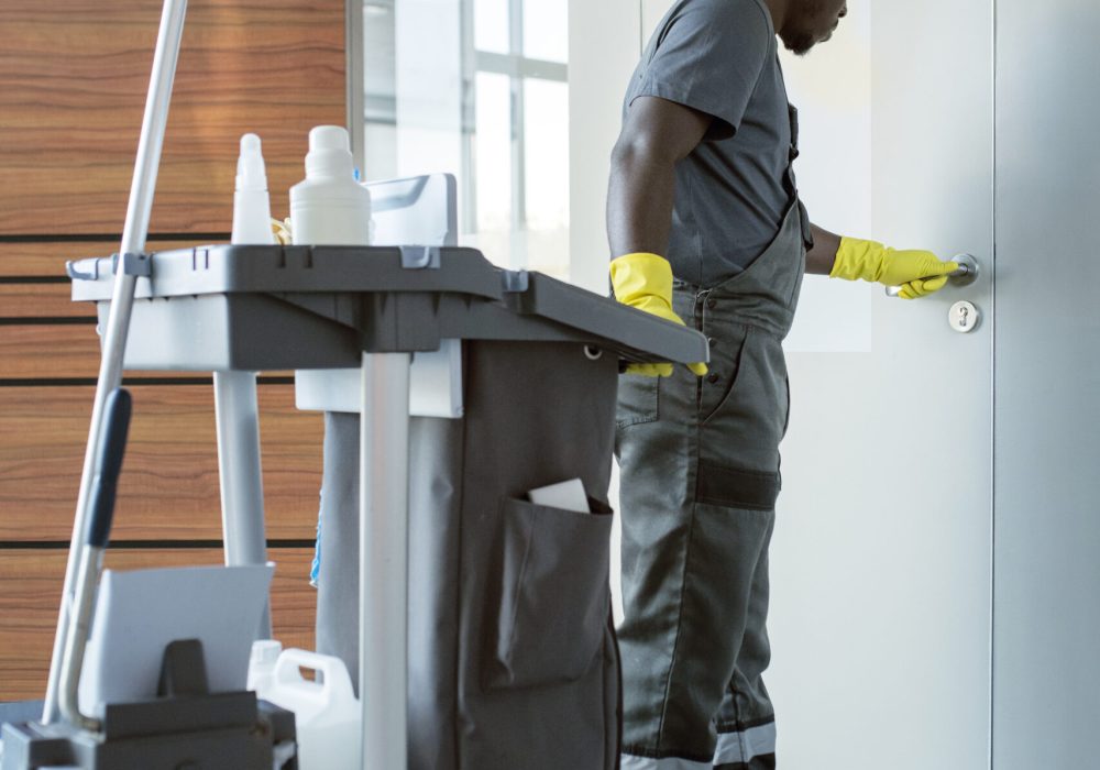 hombre-de-tiro-completo-limpiando-el-pomo-de-la-puerta